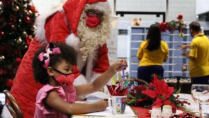 Papai noel entrega presentes a crianças carentes